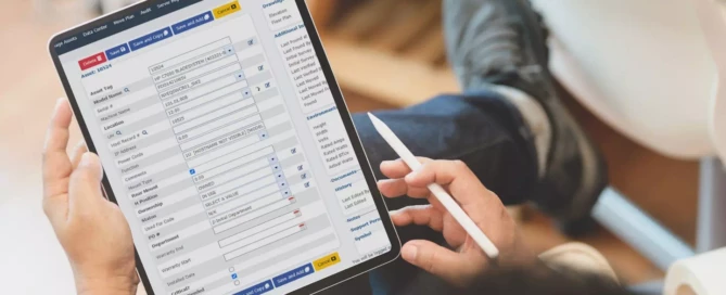 Person looking at Asset Point software on a tablet and holding a stylus.